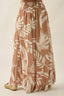 Brown maxi skirt with white leaf pattern on a beige background