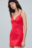 Woman wearing a red dress with thin straps on a gray background