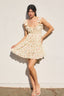 Woman wearing a floral dress against a white wall