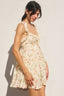 Woman wearing a floral dress against a plain background