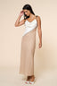 Woman wearing a two-tone dress with a white top and beige skirt on a beige background