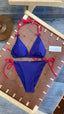 Blue bikini with red straps on a wooden stool