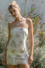 Woman wearing a strapless lace dress in a garden setting