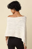 Woman wearing a white knitted shawl against a beige background