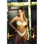 Woman in a light green bikini standing in front of a glass door.