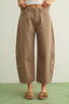 Brown wide-leg pants worn by a person on a light green background