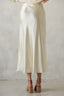 Person wearing a white skirt with a plain background
