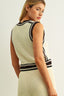 Woman wearing a sleeveless crochet dress with black trim on a light background