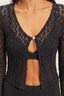 Black lace cardigan with a button detail on a neutral background