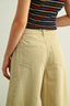 Person wearing beige pants and a striped top on a plain background