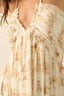 Close-up of a beige dress with a subtle pattern on a plain background