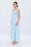 Woman wearing a light blue strapless dress with a slit on a white background