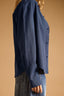 Navy blue shirt worn by a person on a beige background