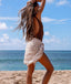 Woman on a beach with ocean and blue sky in the background