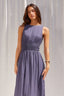 Woman wearing a long purple dress against a plain background