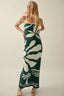 Woman wearing a green and white patterned dress against a plain background