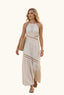 Woman in a coastal beige halter cut out maxi dress