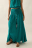 Woman wearing a teal dress with a plain background