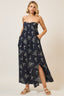 Woman wearing a strapless navy floral dress against a plain background