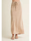 Beige skirt worn by a person on a plain background