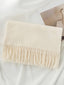 Beige scarf with fringes on a white surface