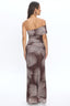 Woman wearing a strapless dress with palm leaf pattern on a white background