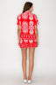 Woman wearing a red and white patterned outfit on a white background