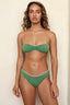 Woman wearing a green bikini against a beige background