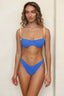 Woman wearing a blue bikini against a beige background