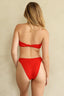 Red bikini worn by a person on a beige background