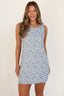 Woman wearing a blue floral dress against a white background