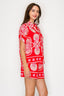 Woman wearing a red set with white floral patterns on a white background