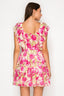Woman wearing a floral dress with pink and yellow flowers on a white background