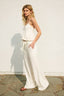 Woman in a white dress standing against a light background