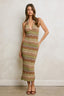 Woman wearing a patterned dress against a plain background