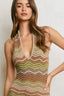 Woman wearing a patterned sleeveless top against a plain background