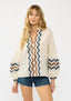 Woman wearing a cream blouse with zigzag pattern on a white background
