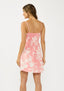 Woman wearing a pink floral dress on a white background