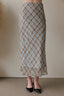 Person wearing a patterned skirt with a neutral background