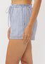 Blue and white striped skirt worn by a person on a plain background
