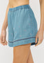 Blue denim skirt with floral embroidery on a white background