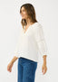 Woman wearing a white blouse and blue jeans on a white background