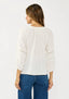 Woman wearing a white blouse and blue jeans on a plain background