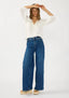 Woman wearing a white blouse and blue jeans on a white background