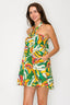 Woman wearing a colorful tropical pattern dress on a white background