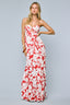 Woman wearing a red and white floral strapless gown on a gray background