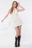 Woman wearing a white dress with black boots on a white background