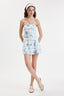 Woman wearing a strapless floral dress on a white background