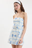 Woman wearing a strapless dress with blue and white pattern on a white background