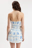 Woman wearing a strapless dress with blue pattern on a white background